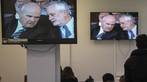 Pantallas en la sala de prensa de la Audiencia donde se ve a Chaves y Griñán charlar