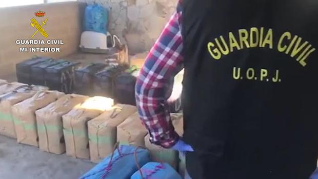 Un agente de la Guardia Civil, ante parte de la droga intervenida en esta operación