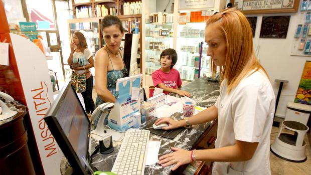 Una farmacéutica atiende a una cliente en una botica de Córdoba