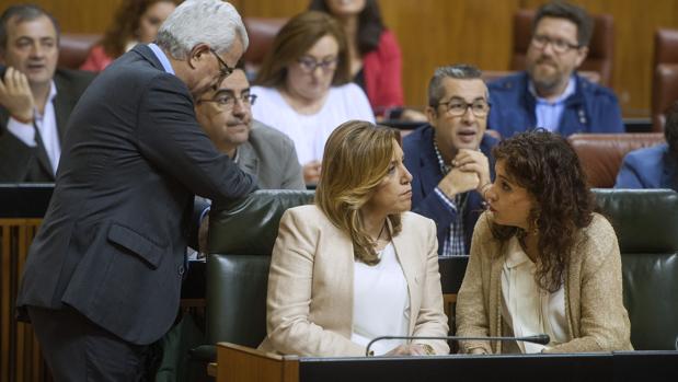 Susana Díaz charla con María Jesús Montero, en un pleno del Parlamento andaluz en 2016