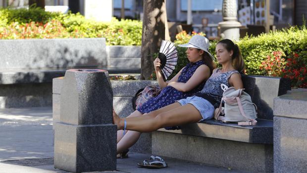 Dos turistas se refrescan en la plaza de Las Tendillas