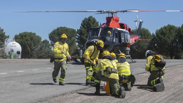 Profesionales del Infoca junto a un helicóptero en la base de Los Villares de Córdoba