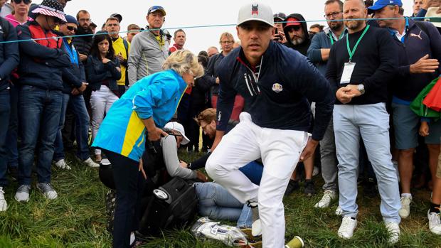 El norteamericano Brooks Koepka atiende a la mujer a la que golpeó con la bota