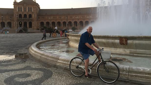 Isaías Parrilla sigue pedaleando a sus casi 80 años. En la imagen, junto a la fuente de la Plaza de España de Sevilla