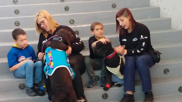 Monitoras en el centro de Evolucan con menores y perros que sirven de terapia
