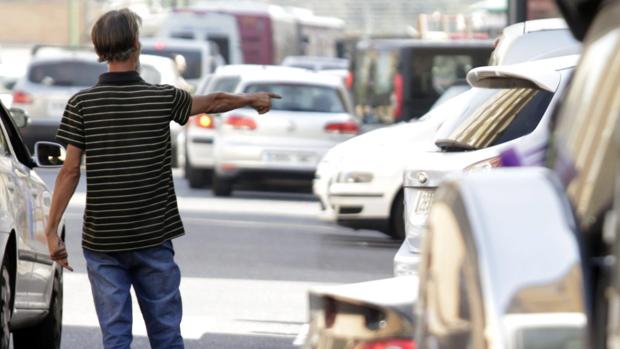 Imagen de un gorrilla aparcando coches en Sevilla