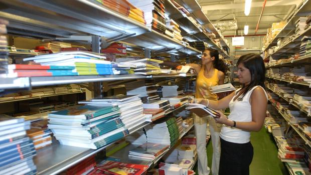 Una mujer busca llibros de texto en un comercio